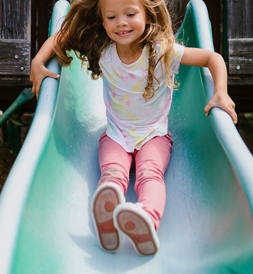 a girl playing on the slide at Pumpkin Patch at Prior Creek Farms